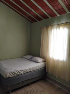 a bedroom with a bed and a window with at Chácara Angola in Andradas +12 photos