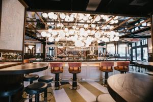a bar with tables and chairs and a chandelier at Hotel MS Maestranza Málaga Centro in Málaga