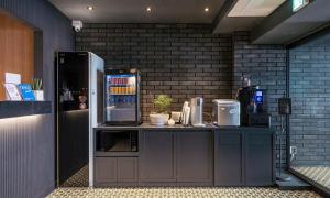 a kitchen with a counter with a refrigerator at 넘버25 신촌점 in Seoul