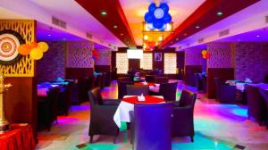 a dining room with tables and chairs and purple lighting at City Point Hotel in Manama +123 photos