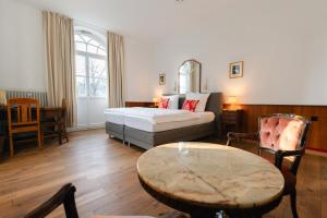 a hotel room with a bed and a table at Villa Widder - Boutiquehotel in Staatsbad Brückenau