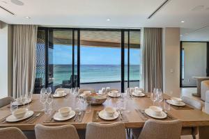 a dining room with a table with a view of the ocean at AQUALINA 1101 PENTHOUSE in Nassau