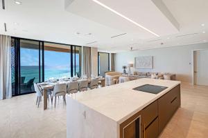 a dining room with tables and chairs and windows at AQUALINA 1101 PENTHOUSE in Nassau