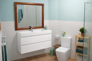a bathroom with a sink and a toilet and a mirror at Villa Tomada Da Luz in Areas