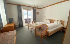 a hotel room with a bed and a table and chairs at Pension Max Schraml in Grundlsee