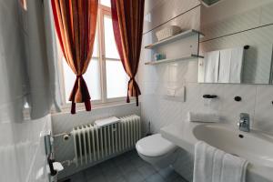 a bathroom with a toilet and a sink and a window at Villa Widder - Boutiquehotel in Staatsbad Brückenau
