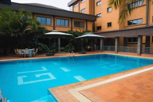 a large blue swimming pool in front of a building at Grand Legacy Hotel in Kigali
