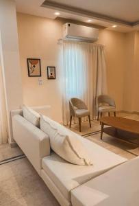 a living room with a white couch and a table at DEight by The Dream Stays in New cairo