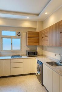 a kitchen with a sink and a dishwasher at DEight by The Dream Stays in New cairo