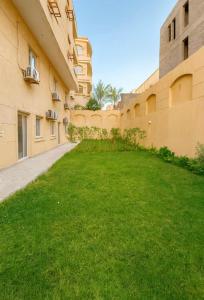 a courtyard of an apartment building with a green lawn at DEight by The Dream Stays in New cairo