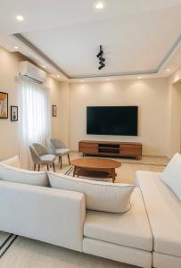 a living room with a couch and a tv at DEight by The Dream Stays in New cairo