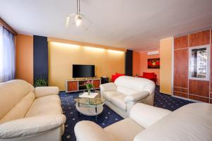 a living room with white furniture and a flat screen tv at Hotel Panon in Hodonín
