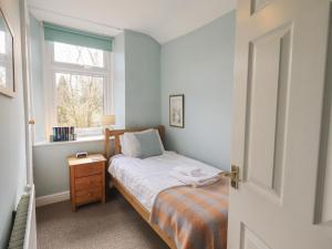a small bedroom with a bed and a window at A River Runs By in Staveley