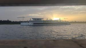 a large boat on the water at sunset at Isis Hotel Nile View in Aswan