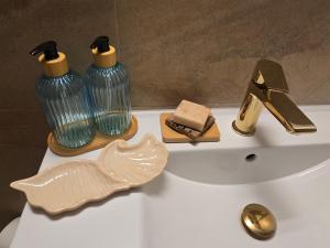 a white sink with two glass vases and a faucet at Family Home FeWo de lux Świnoujście in Świnoujście +28 photos