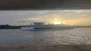 a ferry boat on the water with the sun setting at Isis Hotel Nile View in Aswan