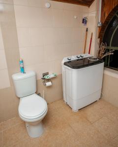 a bathroom with a toilet and a bath tub at Kendi Stays - Rustic Penthouse Attic in Eldoret +18 photos