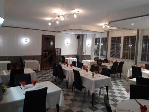 a dining room with white tables and black chairs at Hôtel Relais des Vosges in Monthureux-sur-Saône