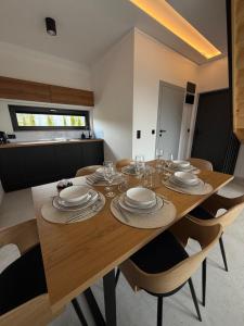 a dining room table with plates and wine glasses at Stodoły pod Łysą Górą in Huta Szklana +12 photos