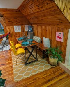 a room with a table and chairs in a cabin at Kendi Stays - Rustic Penthouse Attic in Eldoret