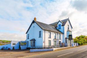 a blue and white building on the side of a road at Rooms at The Highcliffe in Aberporth