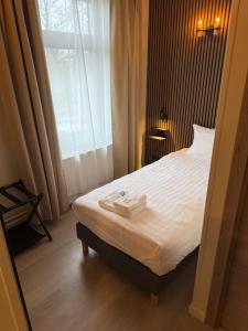 a hotel room with a bed and a window at Hotel Le Relais de Pommard in Francorchamps