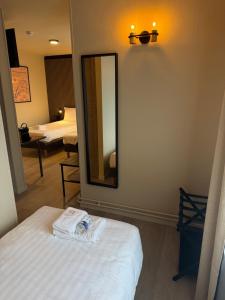 a room with a mirror and a bed and a room with a bed sidx sidx at Hotel Le Relais de Pommard in Francorchamps