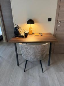 a wooden desk with a chair and a lamp on it at Hotel Le Relais de Pommard in Francorchamps