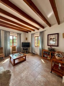 a living room with a couch and a table at Finca Es Puig, rustic estate with views in Es Carritxo
