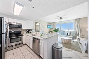 a kitchen with a stove top oven next to a living room at Beach Club 1109 D in Gulf Shores