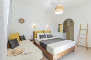 a bedroom with two beds with hats and a ladder at Sunshine in Naxos Chora