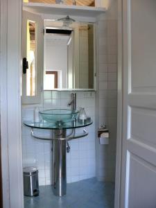 a bathroom with a glass sink and a mirror at Casa Ronco al lago in Pella