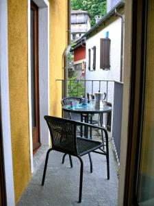 a balcony with a table and a chair on a balcony at Casa Ronco al lago in Pella +19 photos