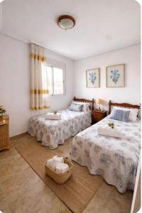 a bedroom with two beds and a window at Casa de Cludia in Santa Pola