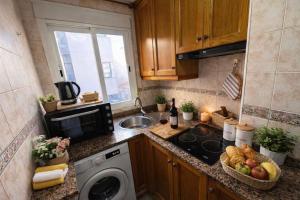 a kitchen with a sink and a washing machine at Casa de Cludia in Santa Pola