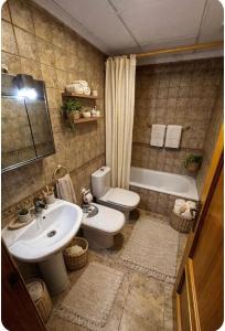 a bathroom with a sink and a toilet and a tub at Casa de Cludia in Santa Pola