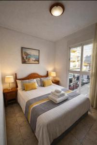 a bedroom with a bed with two lamps and a window at Casa de Cludia in Santa Pola