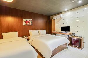 a hotel room with two beds and a television at 렉시호텔 in Seoul +18 photos