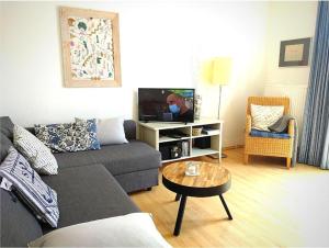 a living room with a couch and a table at FeWo Leuchtturmblick in Kühlungsborn