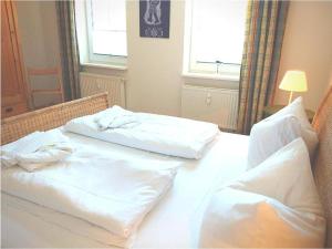 two beds in a hotel room with white sheets at FeWo Leuchtturmblick in Kühlungsborn