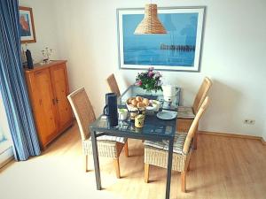 a dining room table with chairs and a table with fruit on it at FeWo Leuchtturmblick in Kühlungsborn