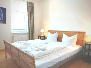 a bedroom with a bed with white sheets and pillows at FeWo Leuchtturmblick in Kühlungsborn