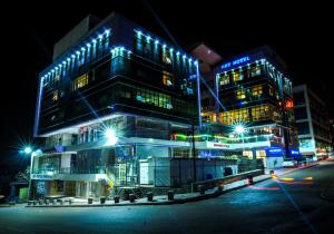 um grande edifício com luzes acesas à noite em Russell Hotel em Kampala