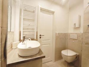 a white bathroom with a sink and a toilet at Sonne, Wind und Meer in Westerland