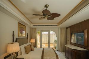 a bedroom with a bed and a ceiling fan at The Leela Palace Jaipur in Jaipur