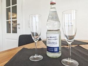 two empty wine glasses and a bottle on a table at Sonne, Wind und Meer in Westerland +9 photos