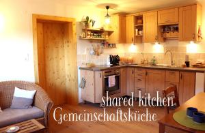 a kitchen with wooden cabinets and a stove top oven at Bio Archehof Zachhiesen - stay & relax in Seekirchen am Wallersee