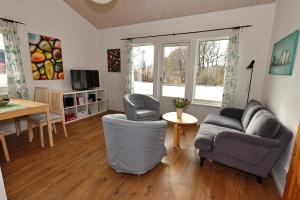a living room with a couch and chairs and a table at Schwedenhaus Westensee 1 EG in Groß Vollstedt