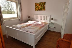 a white bed in a room with a window at Schwedenhaus Westensee 1 EG in Groß Vollstedt