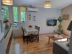 a dining room and living room with a table and chairs at Apartament nad Jeziorem Sławskim in Radzyń